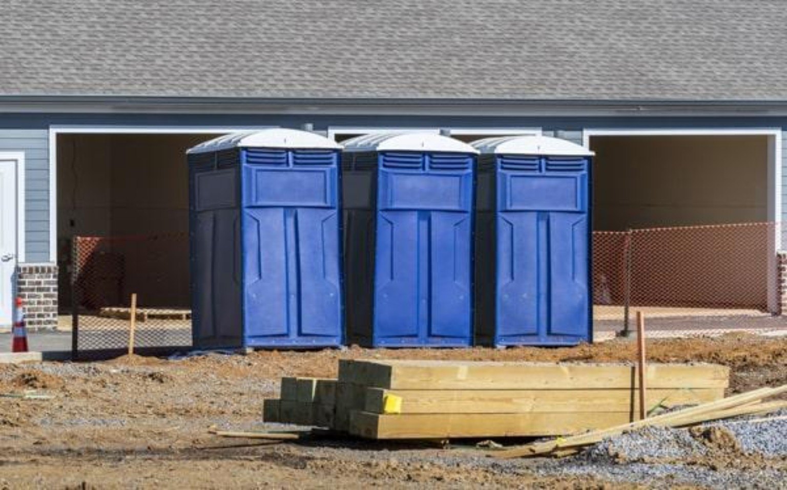 Blue portable toilets at a construction site